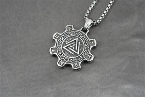 Detail of vintage Valknut pendant with Nordic runes and Celtic knot on steel box chain
