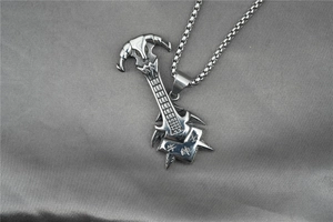 Macro shot of silver guitar neck pendant with bull head engraving on box chain