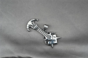 Detail of silver rock punk guitar pendant with Chinese engraving on silk fabric