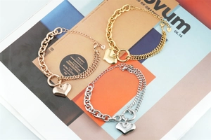 Detailed view of heart charm bracelets in gold, silver, and rose gold with dual chain links