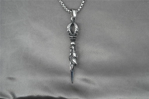 Detailed view of vintage silver steel Vajra pestle pendant with box chain on silk background
