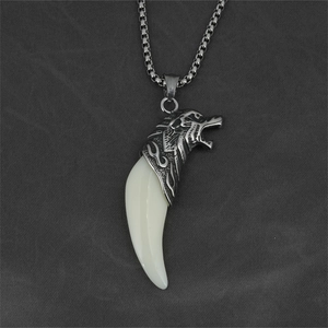 Punk style wolf head fang pendant necklace with silver tone box chain on grey fabric