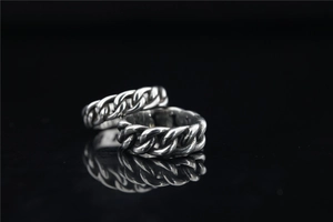 Macro shot of silver S925 vintage cuban chain rings with oxidized metallic texture