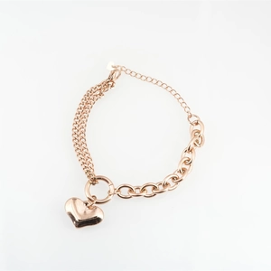 Rose gold heart pendant bracelet with asymmetrical link chain design on white background