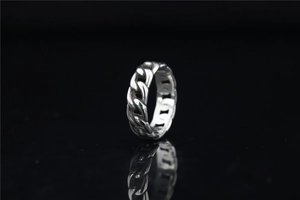Macro shot of a silver Cuban link chain ring with high-gloss finish and mirror reflection
