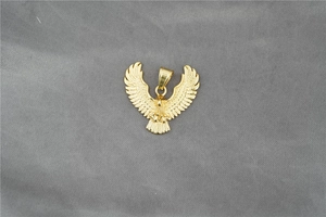 Detailaufnahme des goldenen Adleranhängers mit feinen Federstrukturen am Flügel