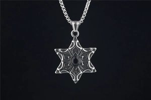Détail macro du pendentif hexagramme avec pierre noire et texture en acier vintage