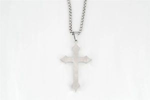 Dettaglio del ciondolo a croce gotica in argento con texture in acciaio spazzolato