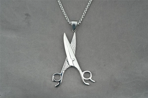 Détail du pendentif ciseaux poli avec motif quadrillé sur chaîne en acier inoxydable