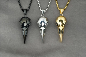 Three Viking raven skull pendants in gold, silver, and black finishes on chain necklaces
