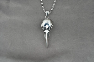 Polished silver raven skull pendant with stainless steel box chain on grey fabric