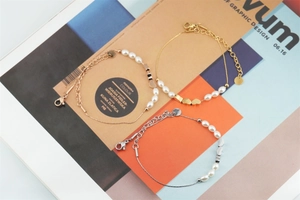 Gros plan de bracelets de perles avec cœurs en finitions or argent et or rose