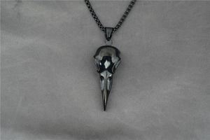 Close-up of a polished black raven skull pendant necklace with dark punk aesthetics
