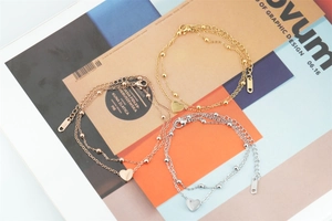 Detailed close-up of three-color double-layered heart charm bracelets in stainless steel