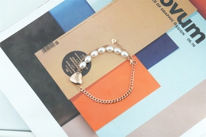 Détail du bracelet cœur en perles et acier titane avec fermoir mousqueton sur magazine