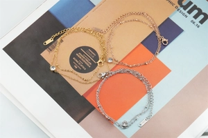 Detail of double-layered stainless steel bracelets with round zircon in gold, rose gold and silver