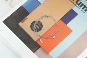 Detail of silver double-layer stainless steel bracelet with a crystal and metal beads