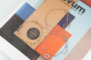 Détails macro de bracelets en acier titane tricolores avec pendentifs ronds en zircon brillant