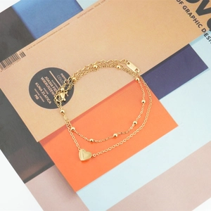 Double-layered gold stainless steel bracelet with small metal beads and a heart pendant