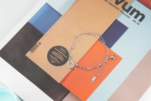 Gros plan sur un bracelet en acier titane double couche avec un pendentif anneau serti