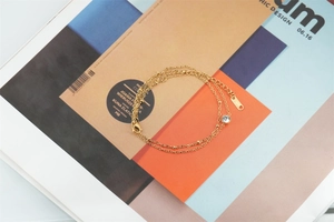 Detail view of 18K gold plated double layer bracelet with zircon charm and lobster clasp