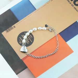 Bracelet asymétrique en perles et acier titane avec pendentif cœur et fermoir homard
