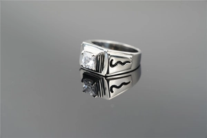 Macro detail of men's square zircon ring with black wave accents on steel band