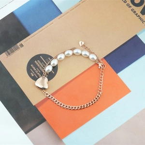 Bracelet en acier titane rose doré avec perles ovales blanches et pendentif cœur poli