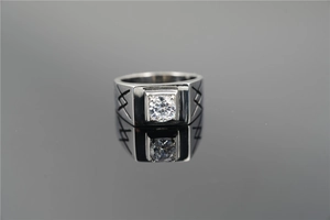 Macro shot of silver titanium ring with round center diamond and geometric textures