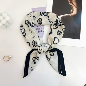 Detailed view of lightweight black and white printed silk scarf with floral patterns