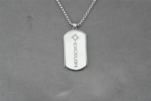 Detail of silver stainless steel dog tag necklace with engraved Excelon logo and box chain