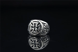Detailed macro view of silver stainless steel ring with black cross pattern and mirror reflection