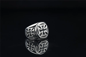 Macro detail of men's vintage cross ring featuring blackened steel texture and engraving
