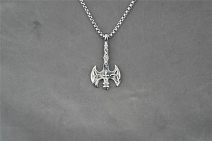 Close-up of Viking axe pendant with Celtic knot patterns and silver box chain detail