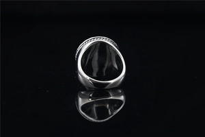 Gros plan d'une bague chevalière vintage avec texture de corde tressée et finition polie