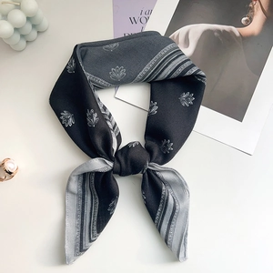 Elegant grey silk scarf with floral print styled with a pearl ring and magazine