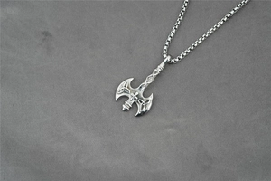 Detailed close-up of a Celtic Viking axe pendant with intricate knotwork on box chain