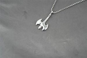 Detailed macro view of silver viking double axe pendant on a polished box chain