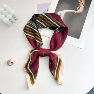Detail view of retro geometric silk scarf with vintage leaf patterns and smooth texture