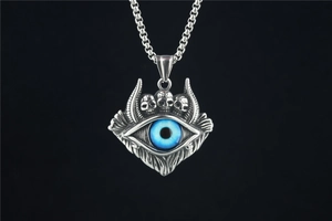 Détail macro du pendentif œil du diable punk avec trois crânes sur chaîne acier