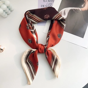 Close-up of vintage silk scarf tied in a bow with classic floral pattern and stripes