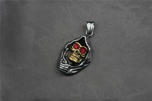 Détail du pendentif crâne viking avec capuche, yeux en cristal rouge et métal bicolore