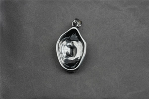 Vue détaillée du pendentif crâne de viking en forme de goutte avec émail noir et argent