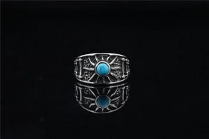 Macro shot of sun pattern vintage ring with turquoise stone and reflective shadow