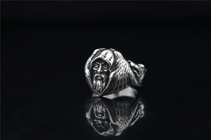Macro detail of vintage silver wizard face ring with intricate beard and cloak engraving