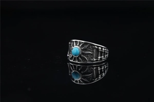 Macro view of vintage titanium steel ring with turquoise stone and sun ray engravings