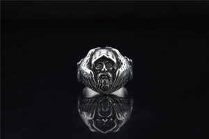 Close-up of vintage silver wolf and wizard ring with detailed mythological engraving