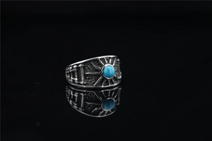 Detailed close-up of retro titanium steel ring featuring turquoise and sunburst engraving