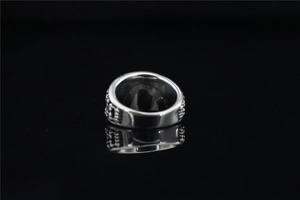 Macro detail of silver vintage titanium steel ring with intricate embossed sun patterns