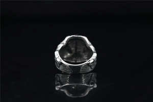 Macro shot of vintage metal ring featuring detailed feather textures and distressed finish